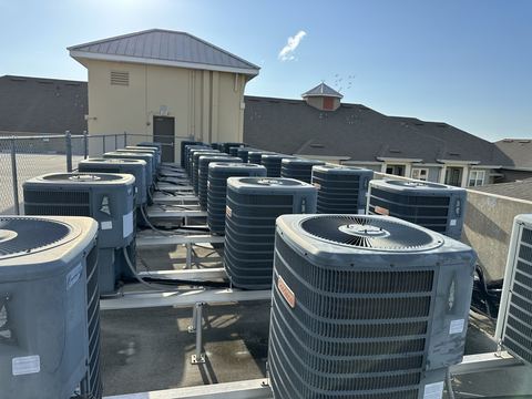 HVAC technician servicing an outdoor condenser unit